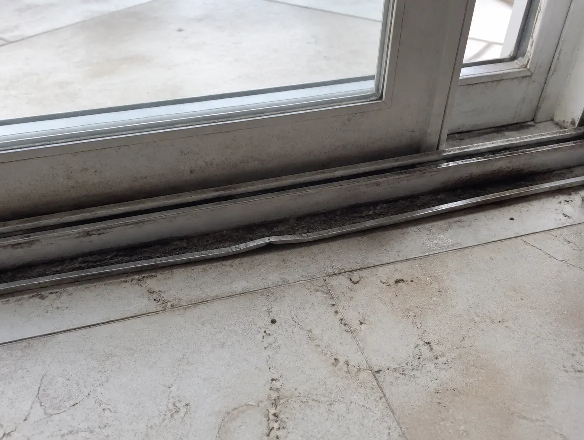 Worn sliding door track with salt-air pitting common in Boca Raton coastal homes